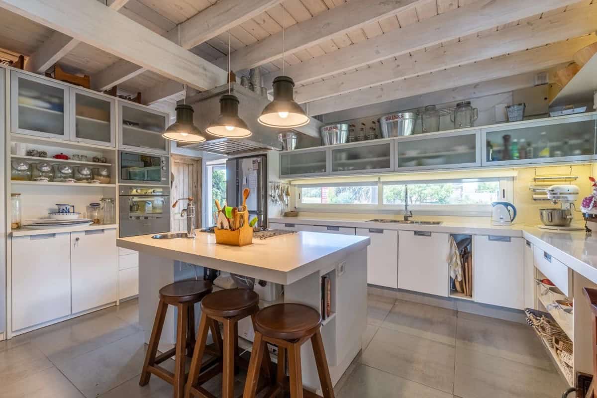 Spacious kitchen featuring white cabinets, a central island, and ample natural light.