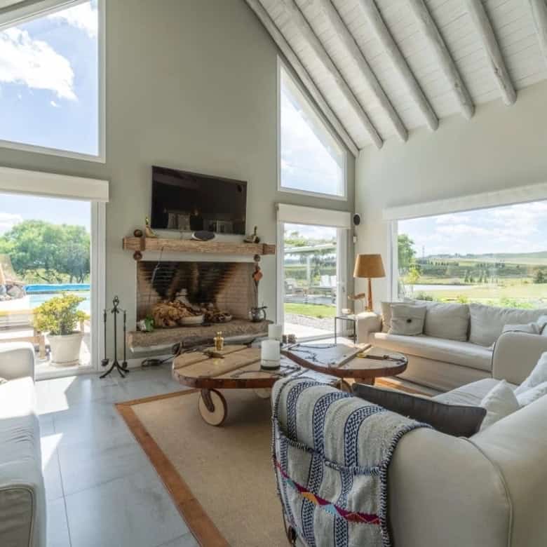 Spacious living room with high vaulted ceilings, large windows, and a fireplace, offering a bright a.