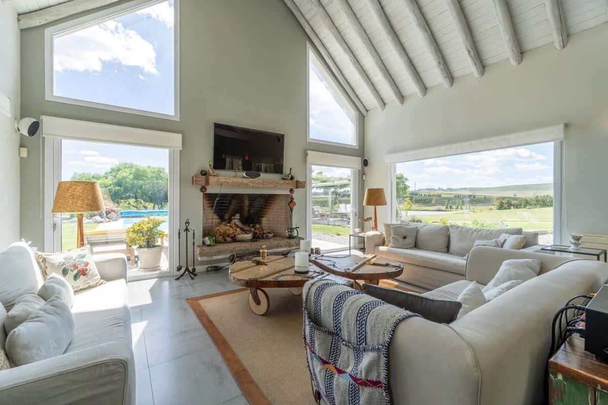 Spacious living room with high vaulted ceilings, large windows, and a fireplace, offering a bright a.
