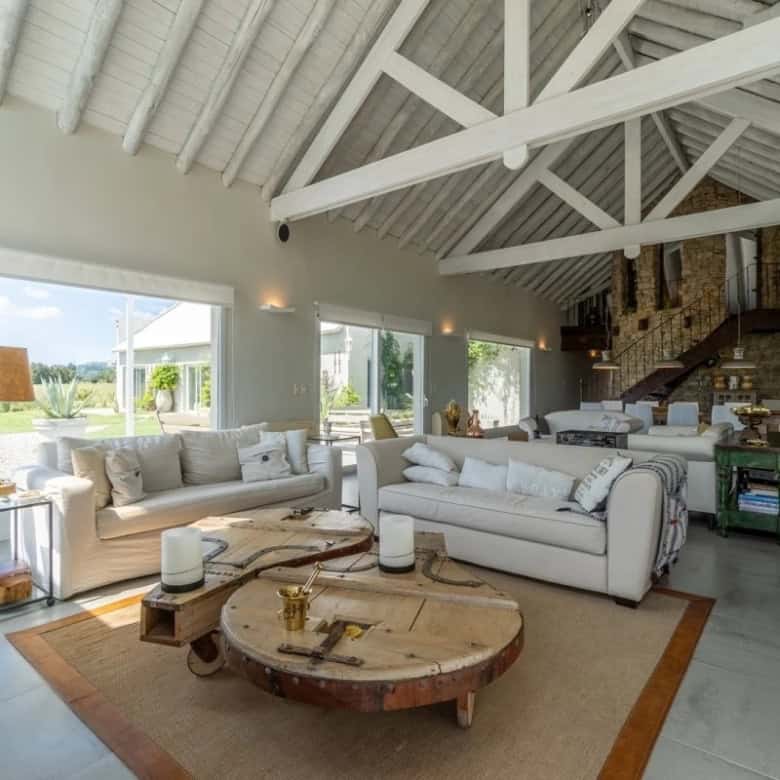 Spacious living room with large windows, high vaulted ceilings, and modern decor in Punta Ballena, M.