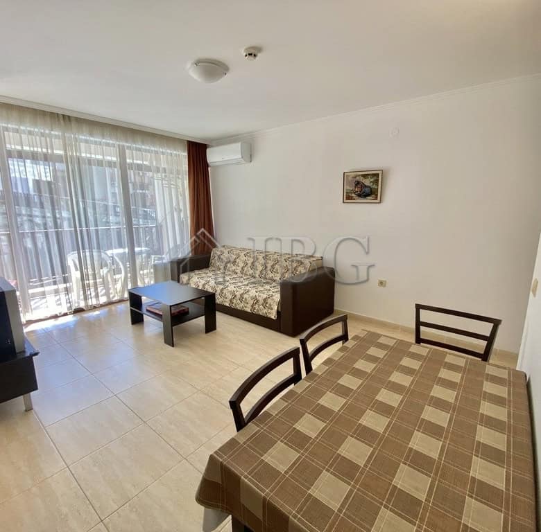 Bright living room with large balcony overlooking the pool.