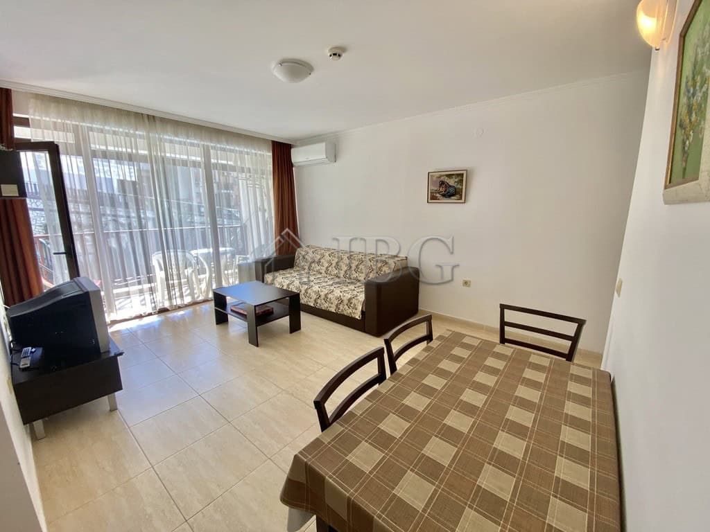 Bright living room with large balcony overlooking the pool.