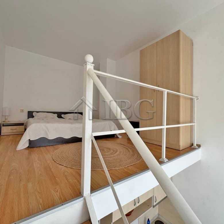 Bright duplex bedroom with white walls and wooden flooring.