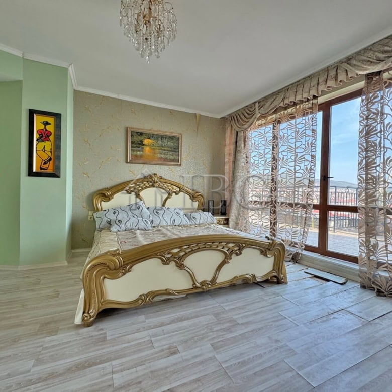 Spacious bedroom with elegant furniture and large windows offering stunning sea views.