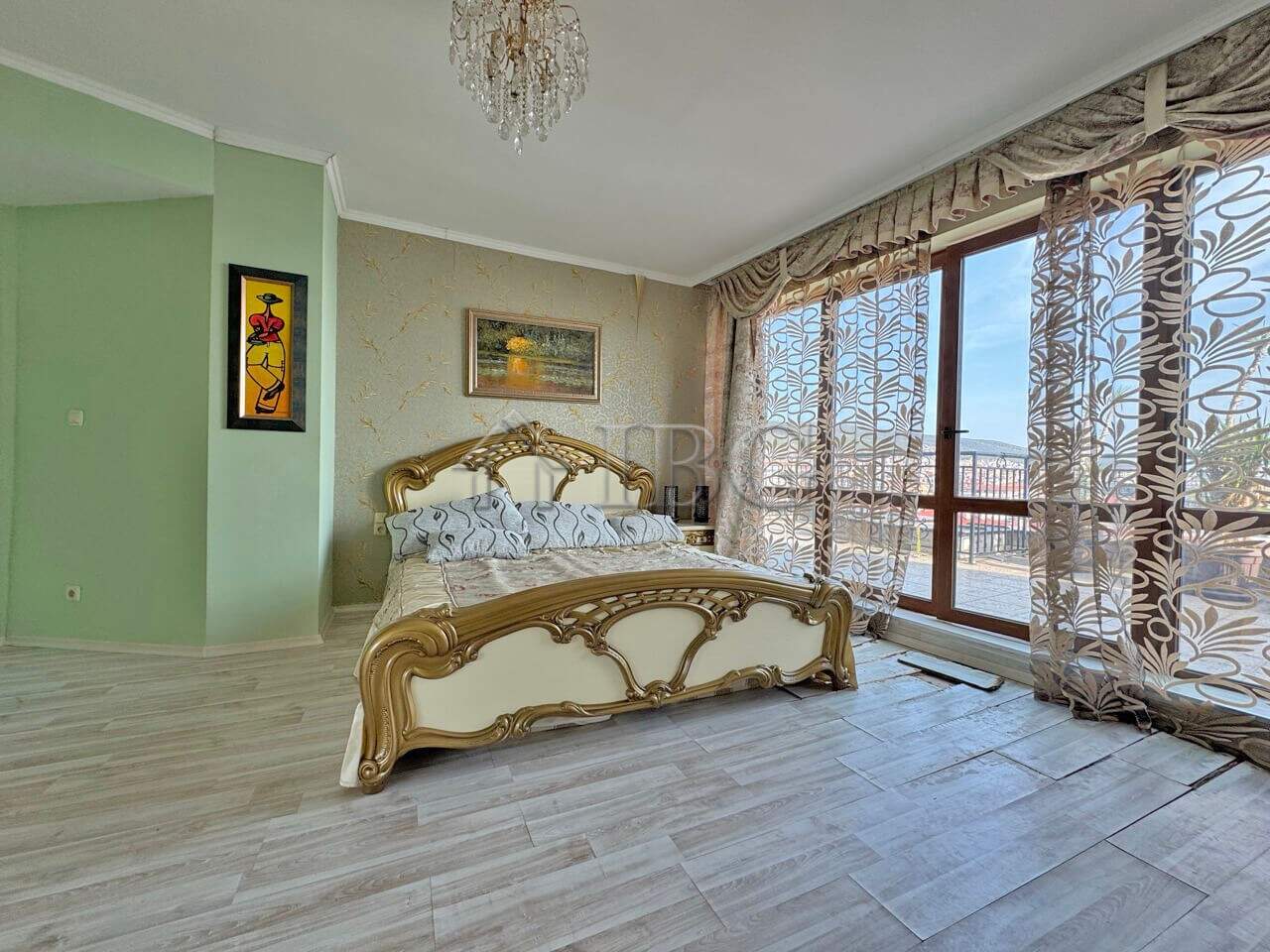 Spacious bedroom with elegant furniture and large windows offering stunning sea views.