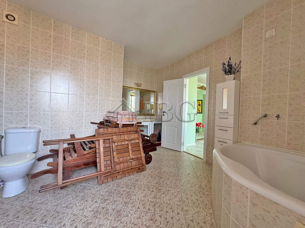 Spacious bathroom with bathtub and storage in a beachfront apartment at Grand Hotel Sveti Vlas.