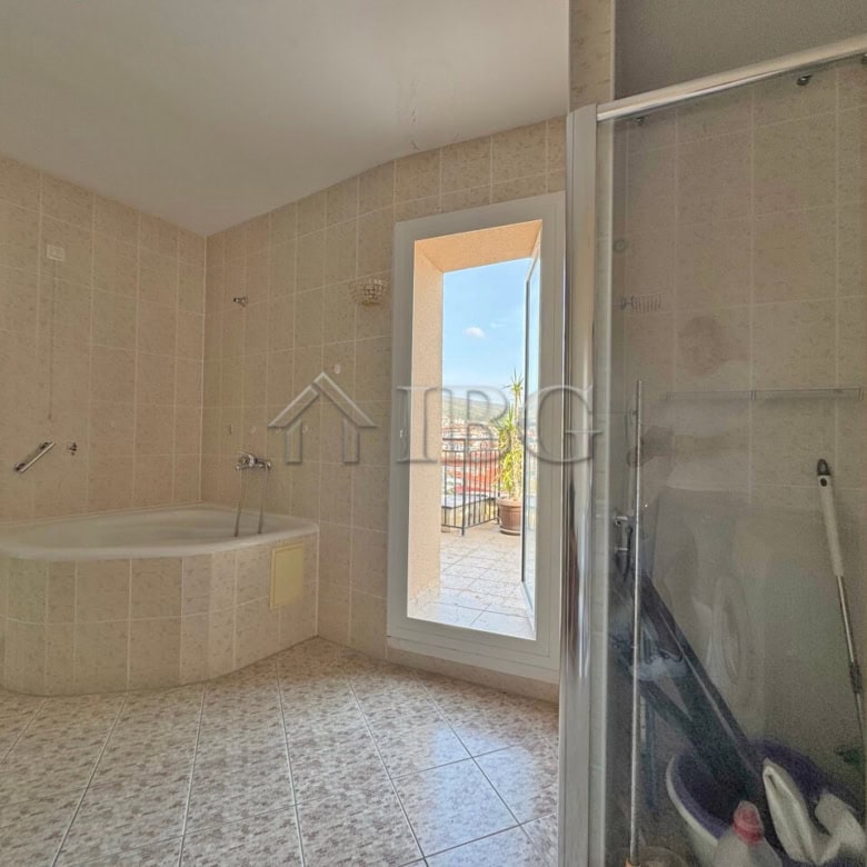 Spacious bathroom with bathtub and shower in a beachfront apartment at Grand Hotel Sveti Vlas.