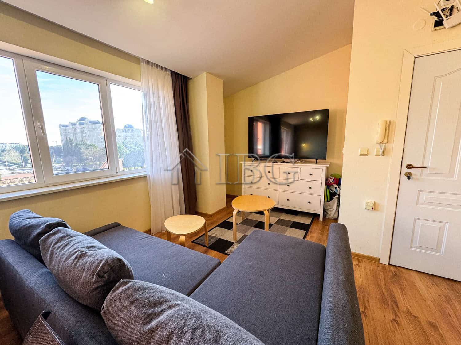 Bright living room with sea view, modern furniture, and large windows in Sunny Beach apartment.