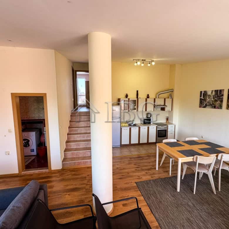 Bright living space with open-plan kitchen and dining area, featuring stylish furniture and scenic s.