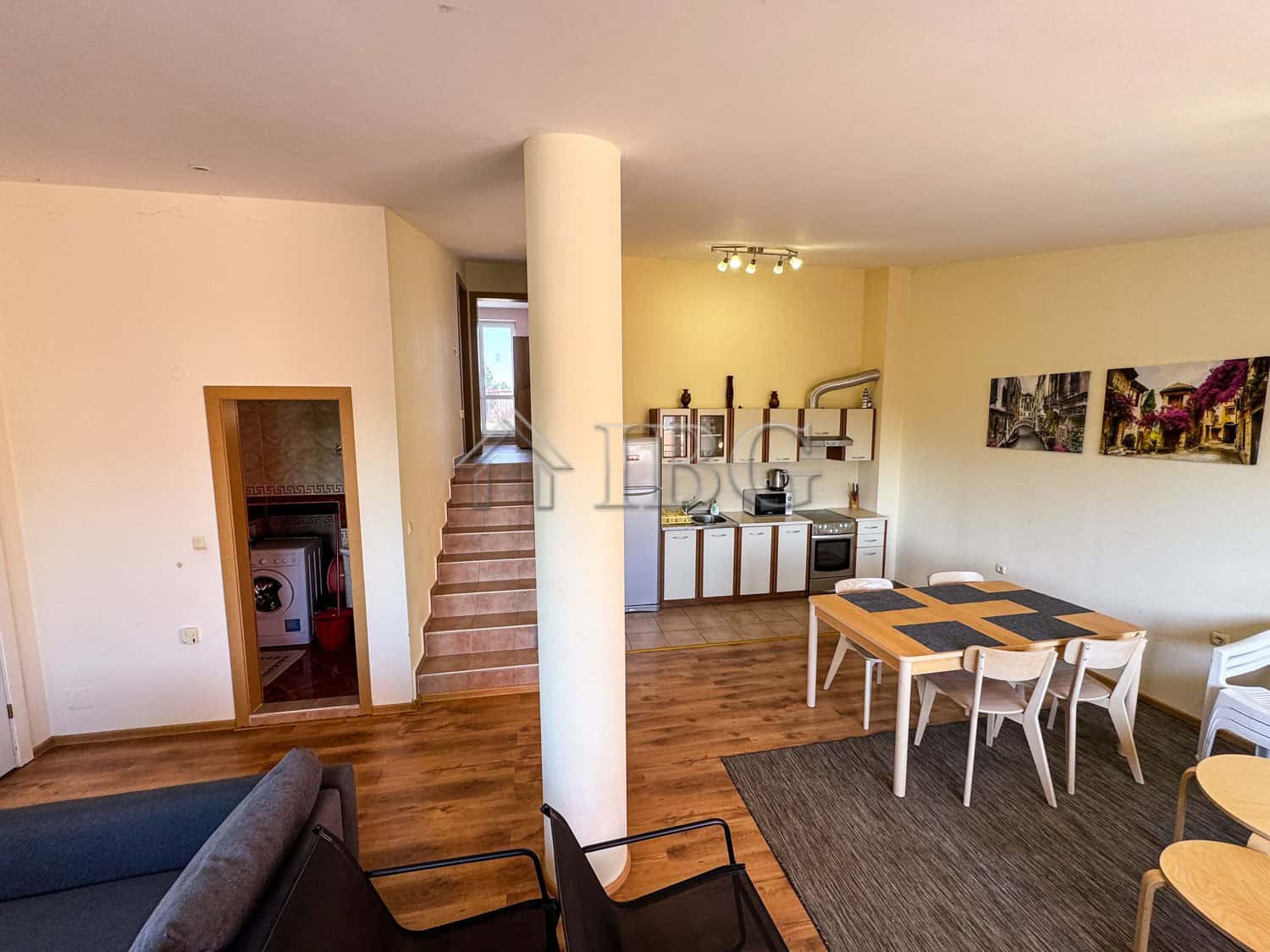 Bright living space with open-plan kitchen and dining area, featuring stylish furniture and scenic s.