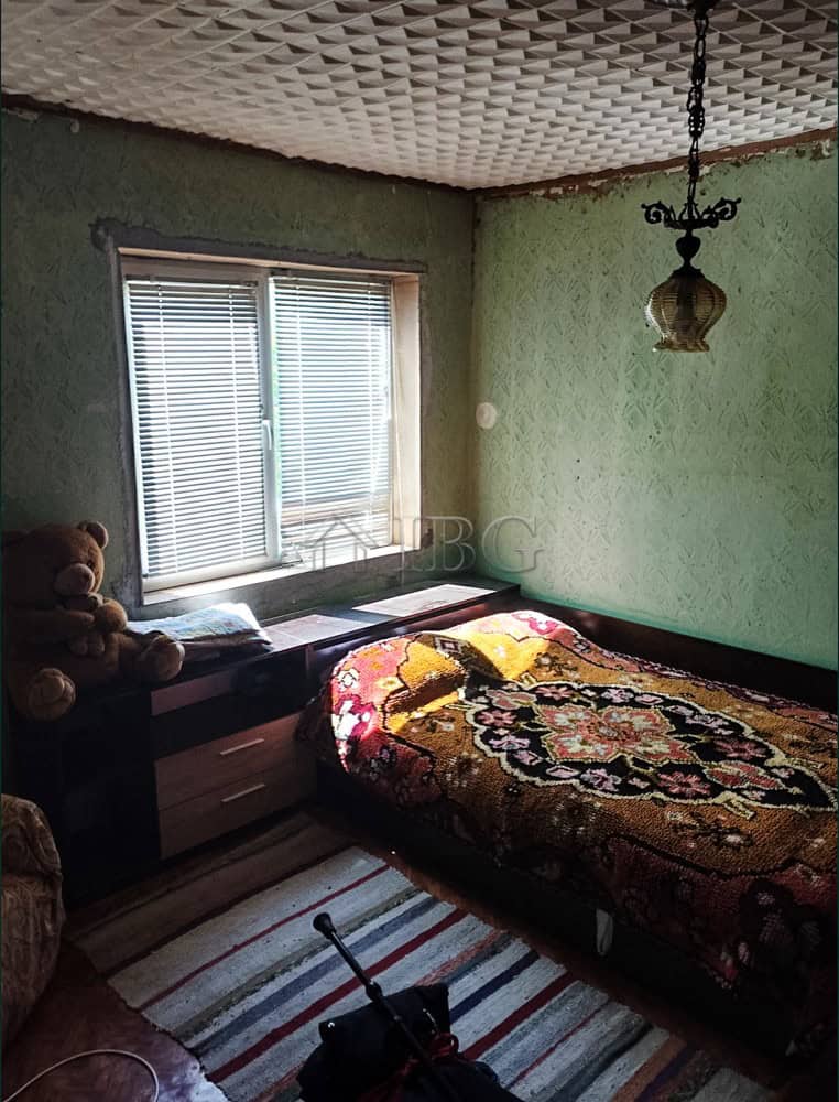 Bright bedroom with large window and vintage decor.