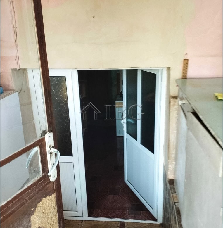 Modern glass door entrance to a two-storey house with garden view.