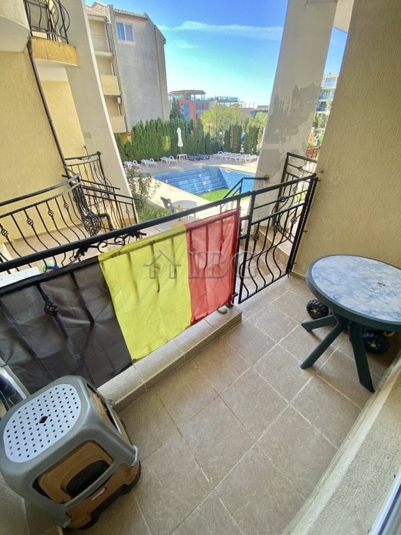 Balcony of a two-bedroom apartment in Sveti Vlas, featuring a small table and colorful towels, overl.