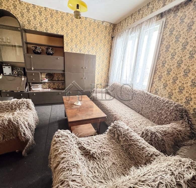 Comfortable living room featuring floral wallpaper and plush furniture in Shtraklevo Village.