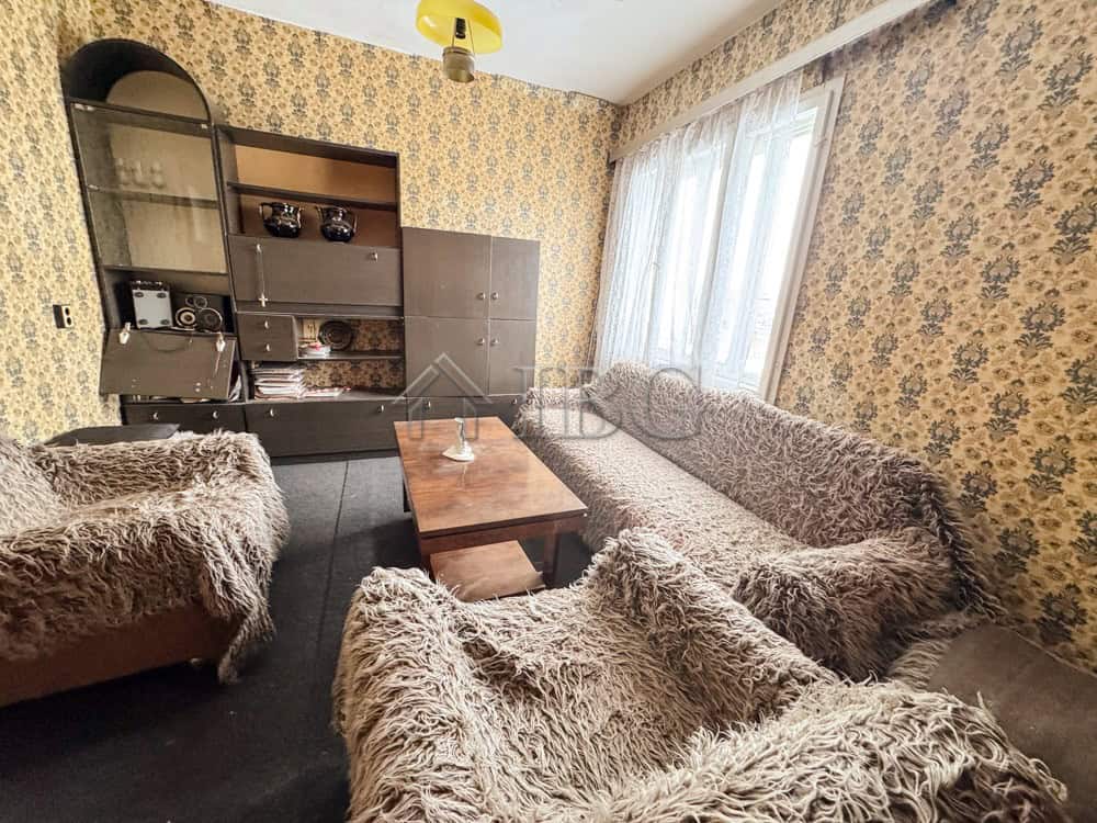 Comfortable living room featuring floral wallpaper and plush furniture in Shtraklevo Village.