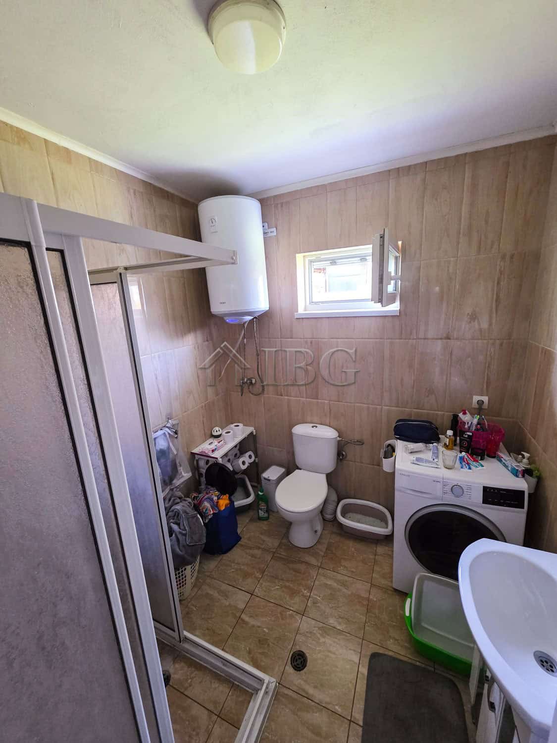 Bright bathroom in a detached house with a garden, featuring modern fixtures and a small window for.