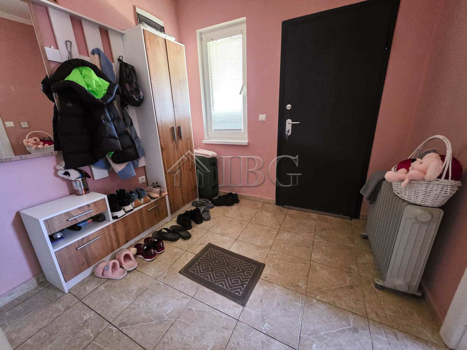 Entrance hall with shoe rack, coat hooks, and a window in a detached house near Sunny Beach.