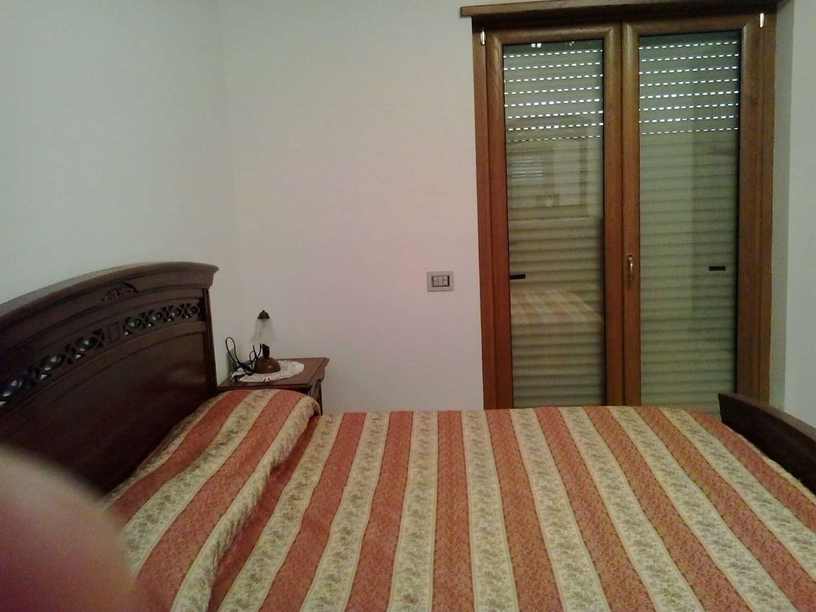 House interior with double bed and wooden furniture in Orsara di Puglia, Italy.