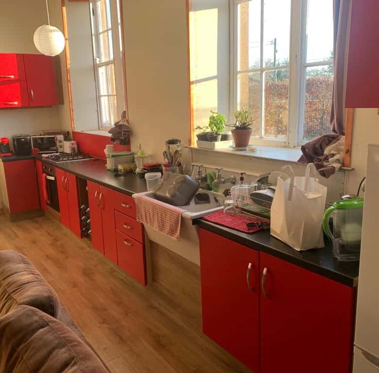 Bright kitchen with red cabinets and large windows in Mooncoin, Ireland.