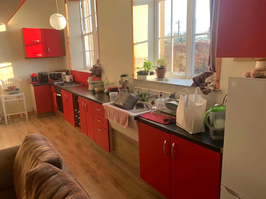 Bright kitchen with red cabinets and large windows in Mooncoin, Ireland.