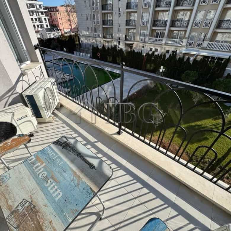 Balcony with outdoor air conditioning units overlooking a garden in a new residential complex.