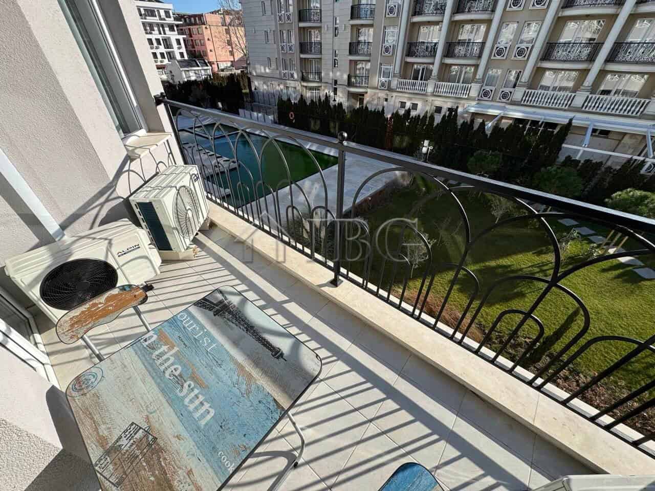 Balcony with outdoor air conditioning units overlooking a garden in a new residential complex.