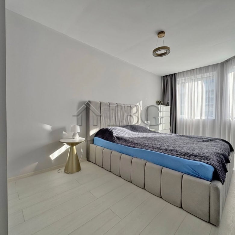 Spacious bedroom with contemporary decor and large window in J’adore Secret Garden complex.