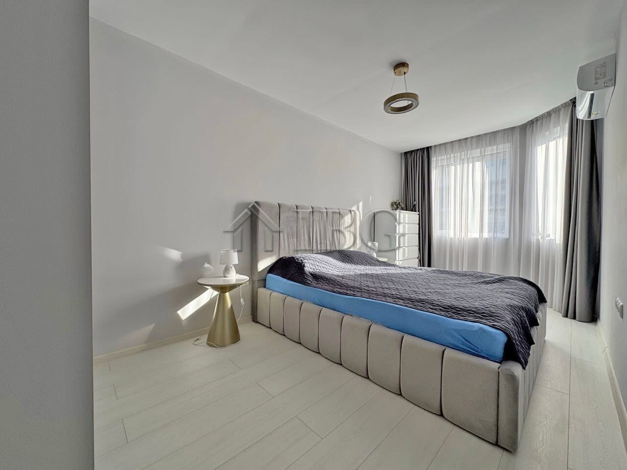 Spacious bedroom with contemporary decor and large window in J’adore Secret Garden complex.