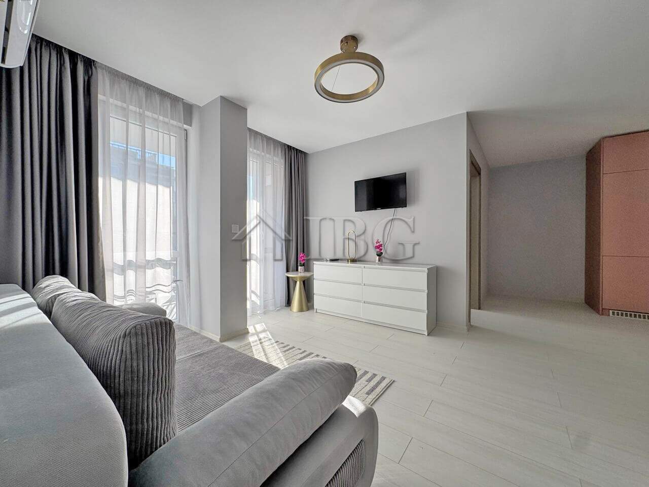 Bright living room with large windows and contemporary decor in J’adore Secret Garden.