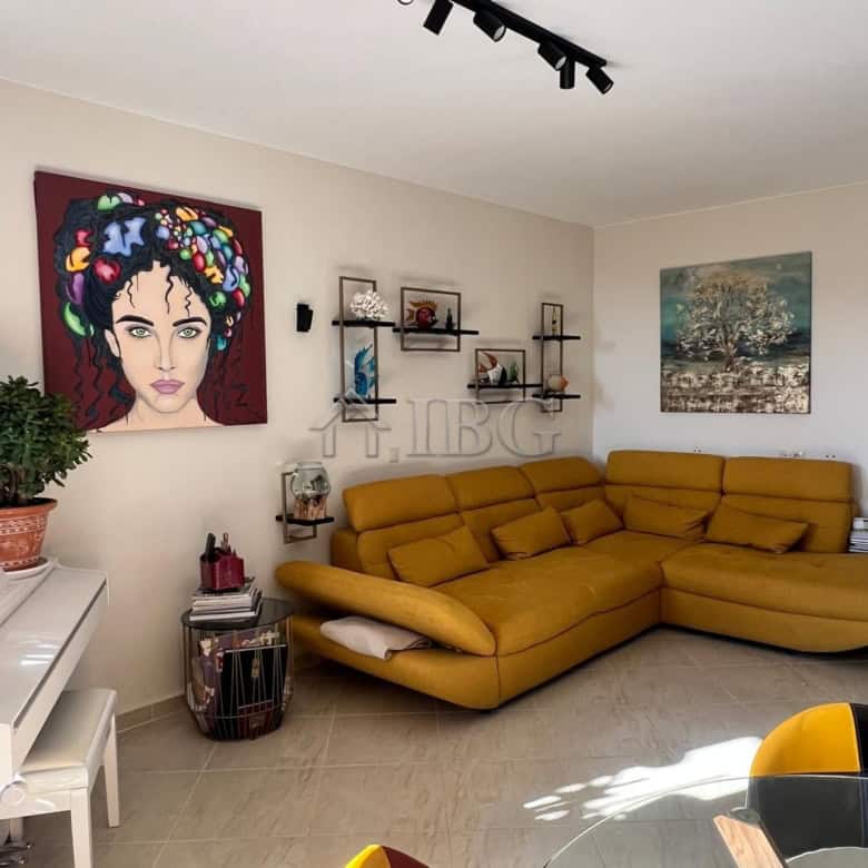 Bright living room with modern decor and colorful artwork, featuring a comfortable yellow sofa and s.