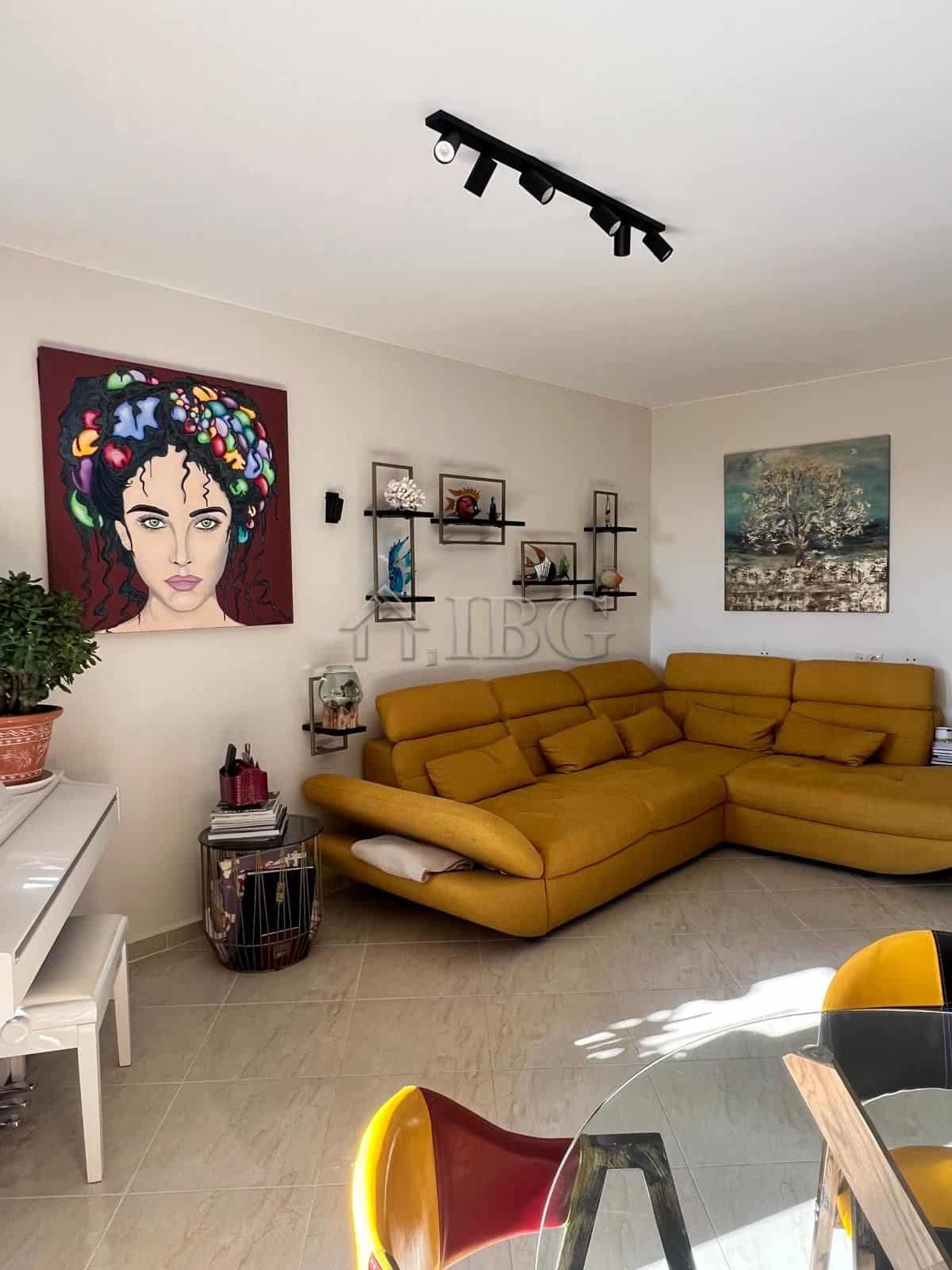 Bright living room with modern decor and colorful artwork, featuring a comfortable yellow sofa and s.