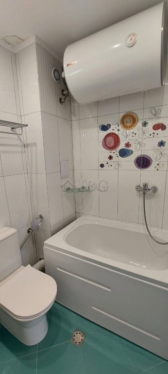 Bathroom featuring a water heater, bathtub, and modern fixtures in a clean, bright space.