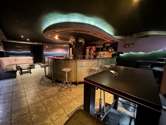 Modern bar interior with seating and lighting in prime commercial location.