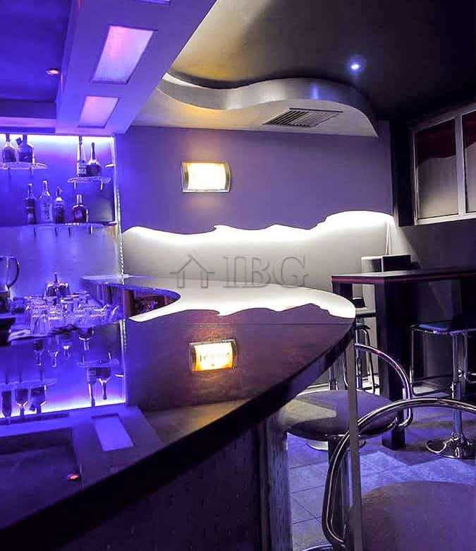Modern bar interior with ambient lighting and stylish seating areas.