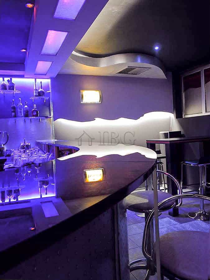 Modern bar interior with ambient lighting and stylish seating areas.