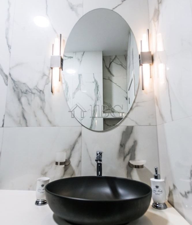 Modern bathroom with marble walls and stylish lighting.