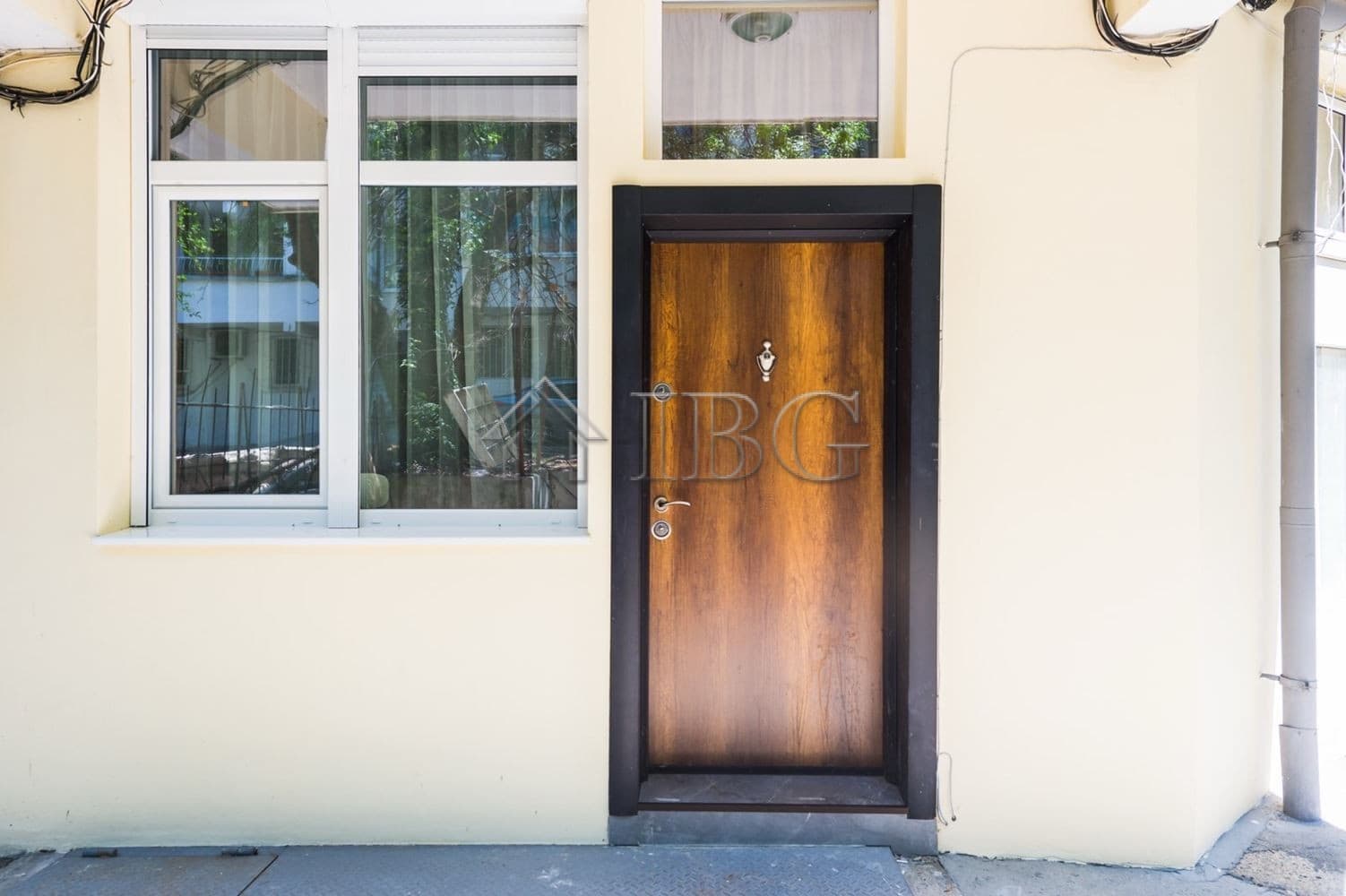 Entrance of a luxury 1-bedroom apartment with wooden door and large windows in Lazur District, Burga.