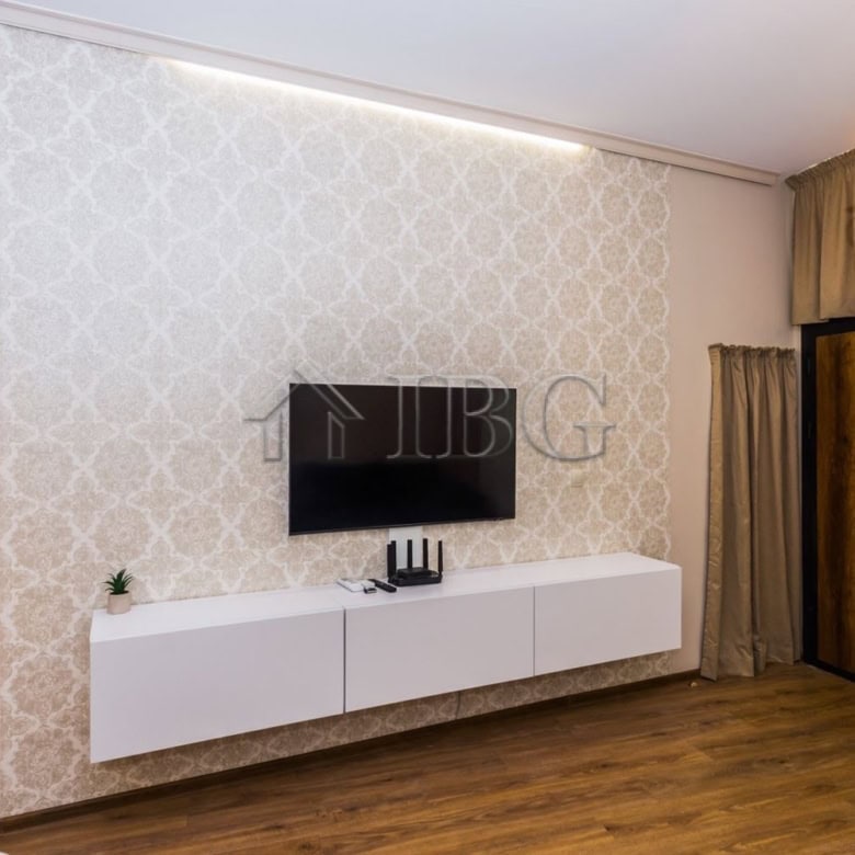 Stylish living room featuring a wall-mounted TV, decorative wallpaper, and contemporary furniture in.