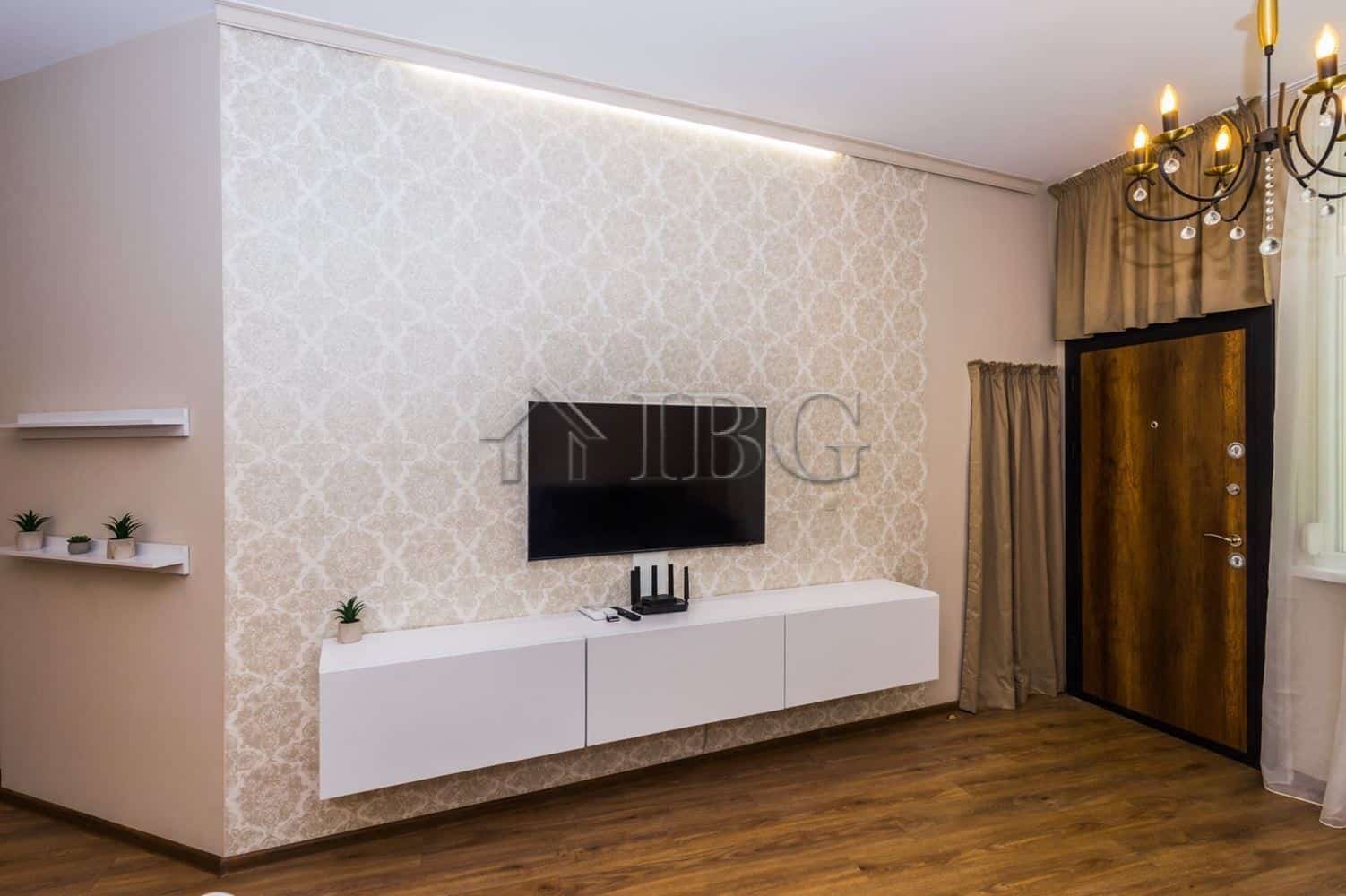 Stylish living room featuring a wall-mounted TV, decorative wallpaper, and contemporary furniture in.