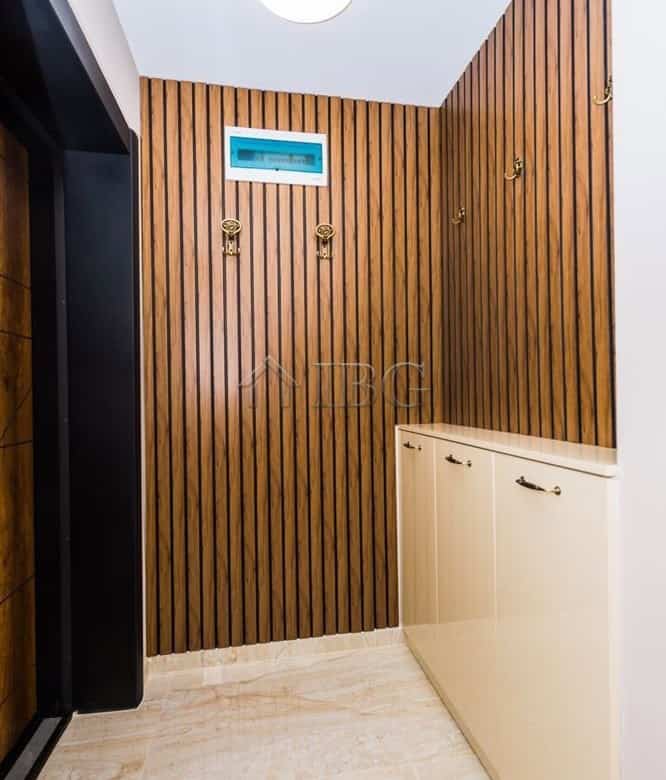 Apartment interior with wooden wall panels and a white cabinet.