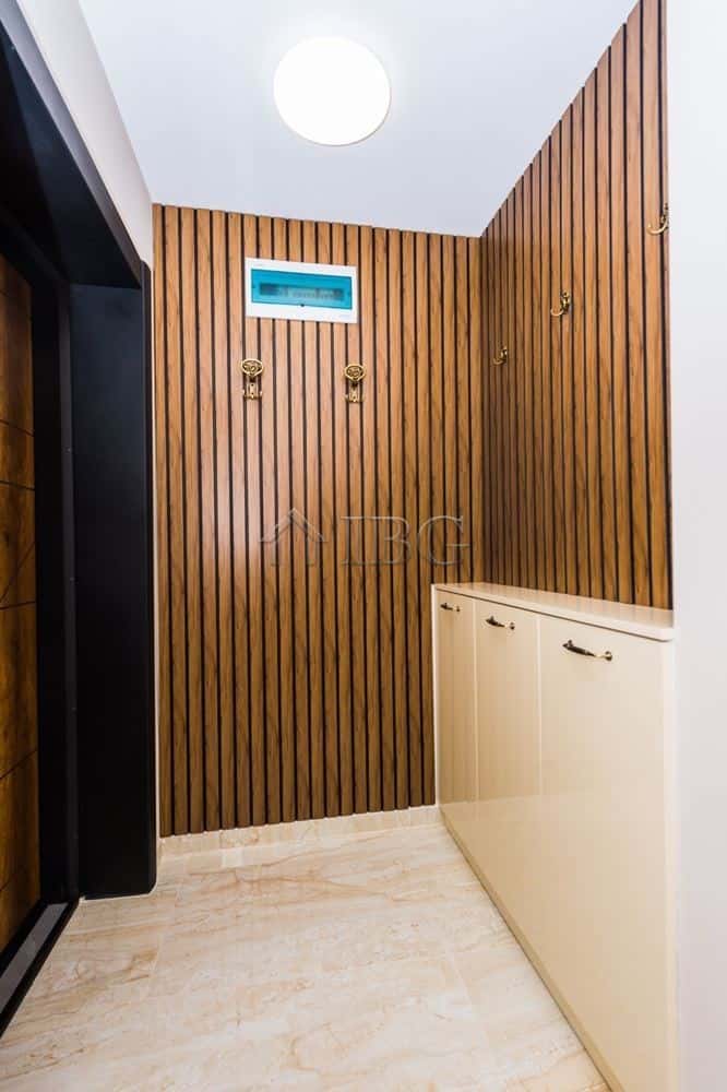 Apartment interior with wooden wall panels and a white cabinet.