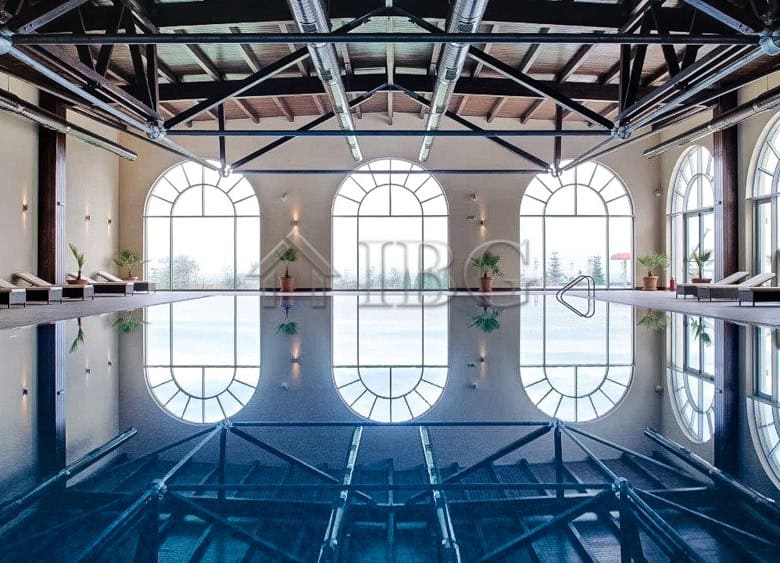 Indoor swimming pool with large arched windows at Lighthouse Golf & Spa Resort.