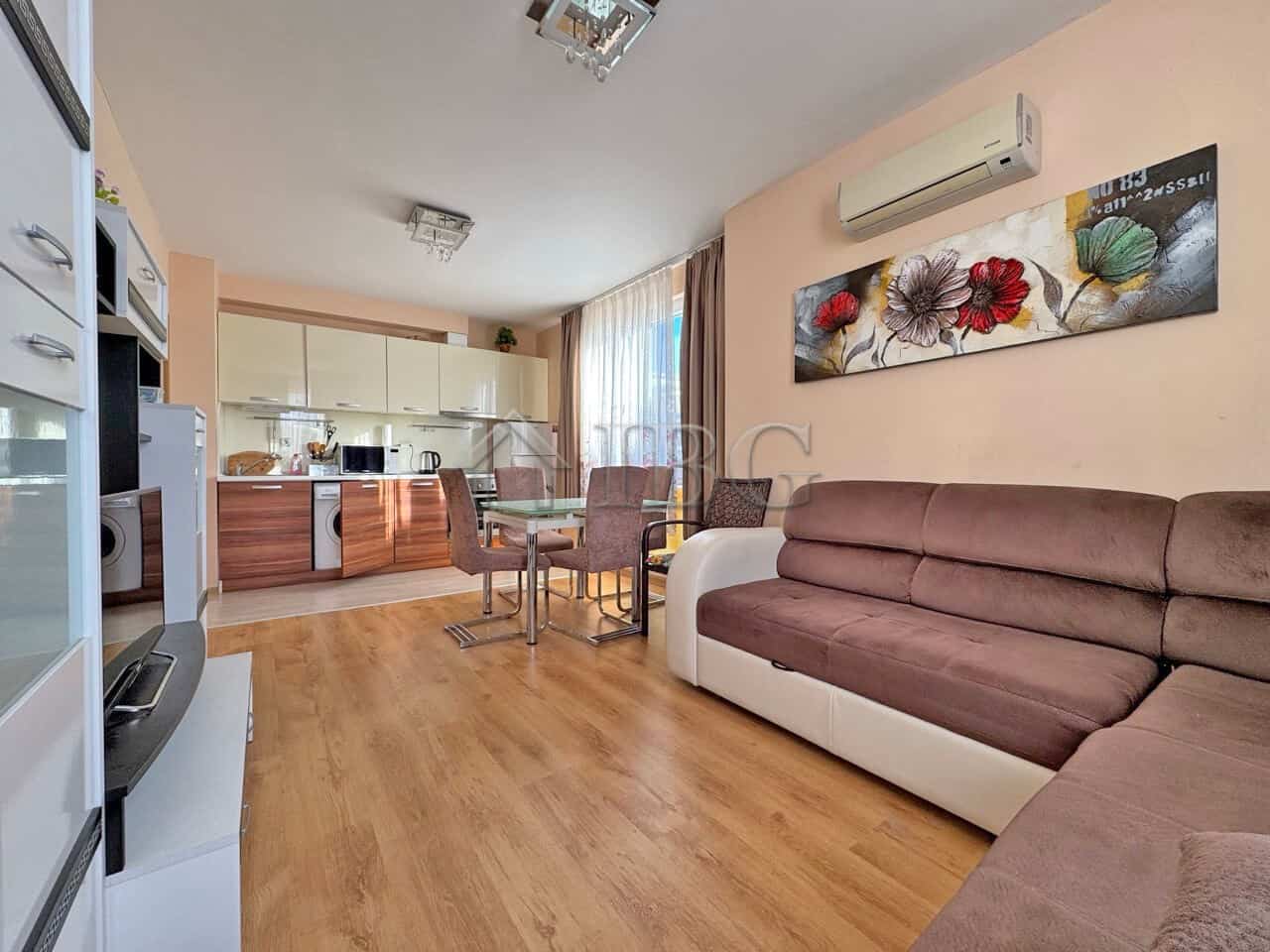 Bright living room with sofa, dining area, and open kitchen in Messembria Palace, Sunny Beach.