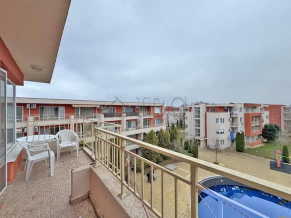 Balcony view of a pool and residential buildings in Sunny Beach.
