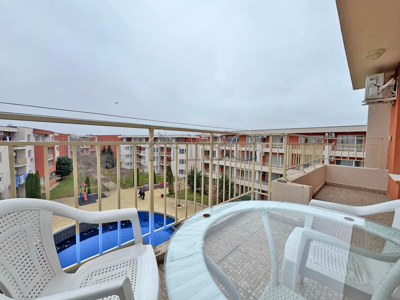 Bright view of the pool from a balcony in a 1-bedroom apartment at Nessebar Fort Club, Sunny Beach.