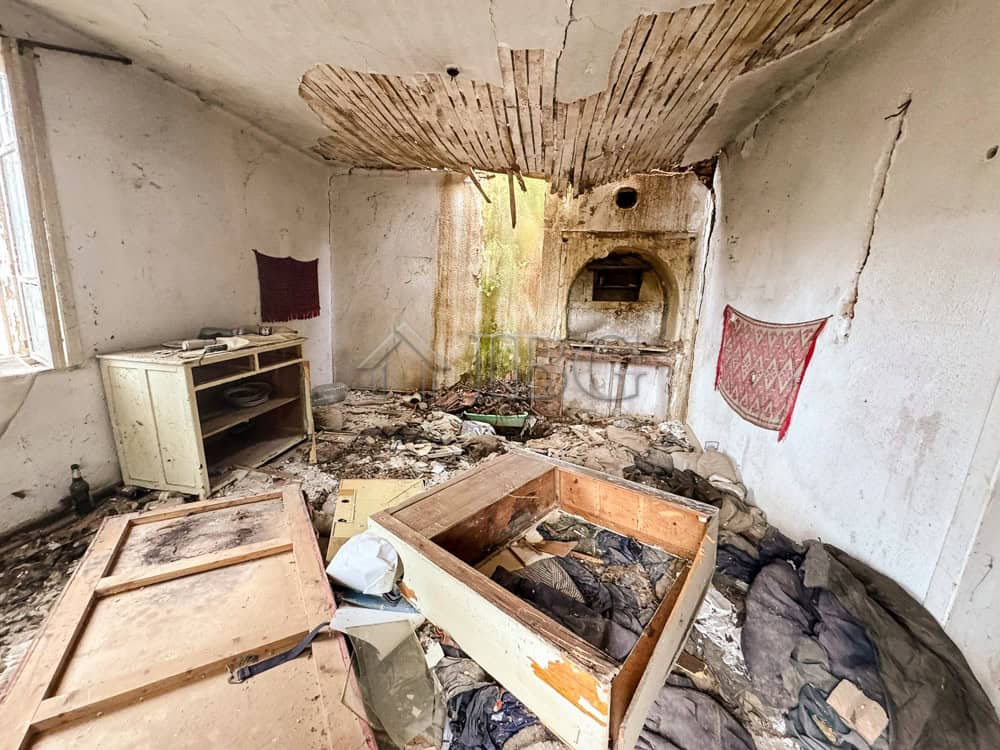 Abandoned room with damaged walls and ceiling, showcasing a potential renovation near the sea. Large.