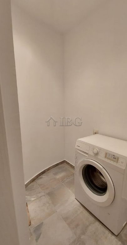 Laundry area featuring a washing machine in a compact, clean space.