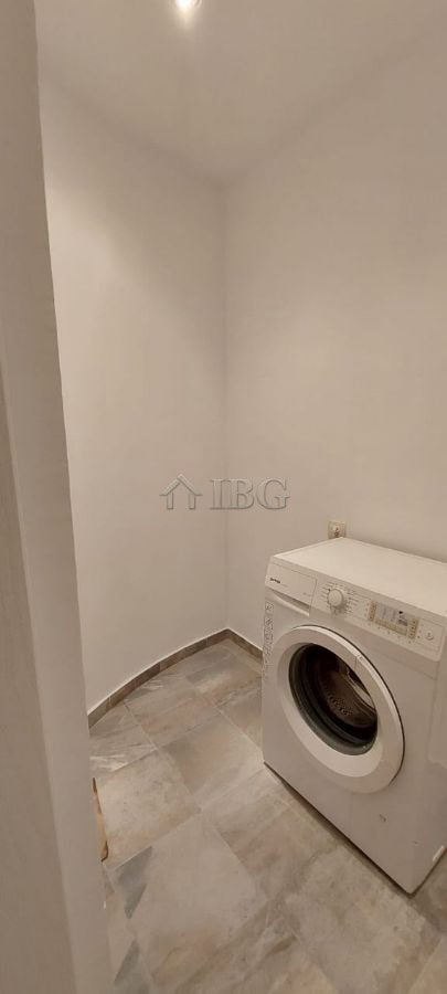 Laundry area featuring a washing machine in a compact, clean space.