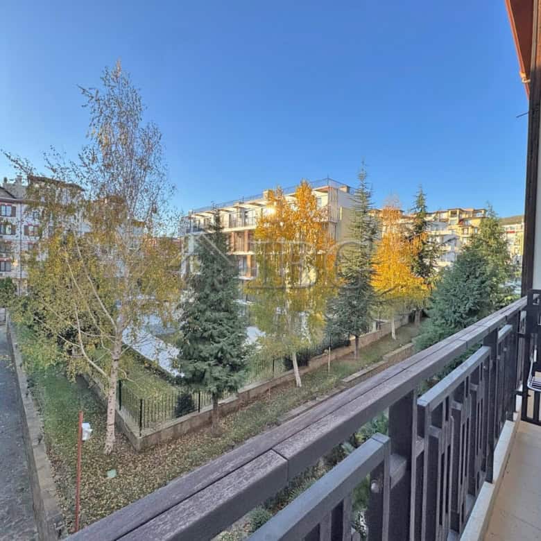 Bright view from balcony overlooking green trees and neighboring buildings in Sveti Vlas.