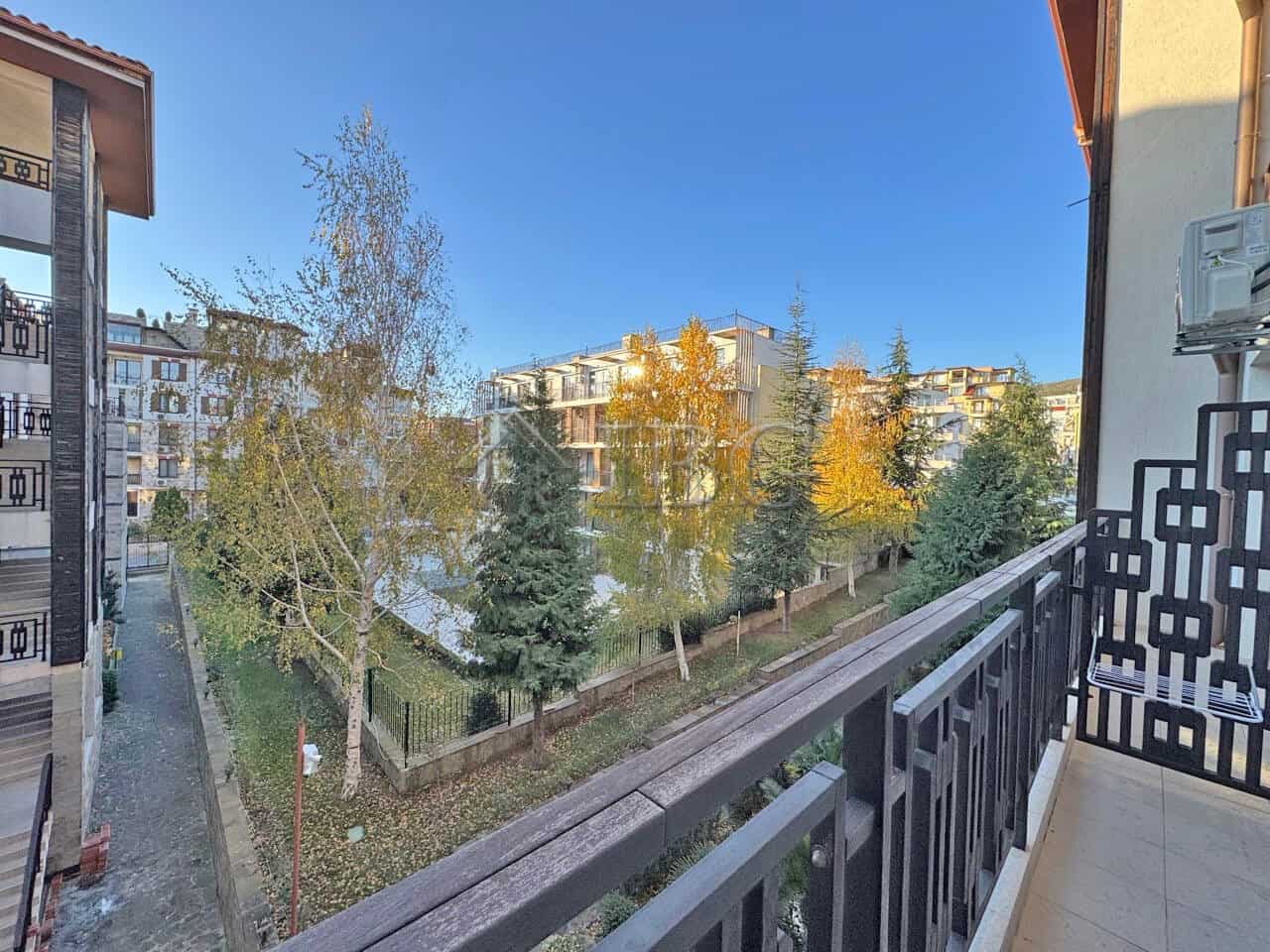 Studio for sale in Panorama Bay 2, Sveti Vlas, 200 m from the sea Bright view from balcony overlooking green trees and neighboring buildings in Sveti Vlas.